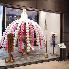 お祭り展示室に展示されている萬田の花傘鉾の写真、法被や鐘、笛も展示されている。