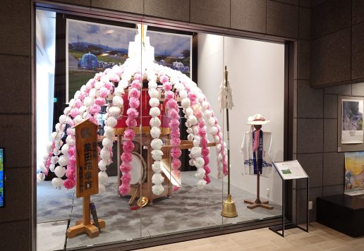 お祭り展示室に展示されている萬田の花傘鉾の写真、法被や鐘、笛も展示されている。