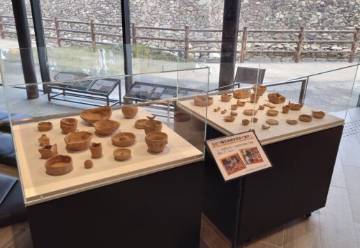 土器が展示ケースの上に並べられている様子。ケースは2つ