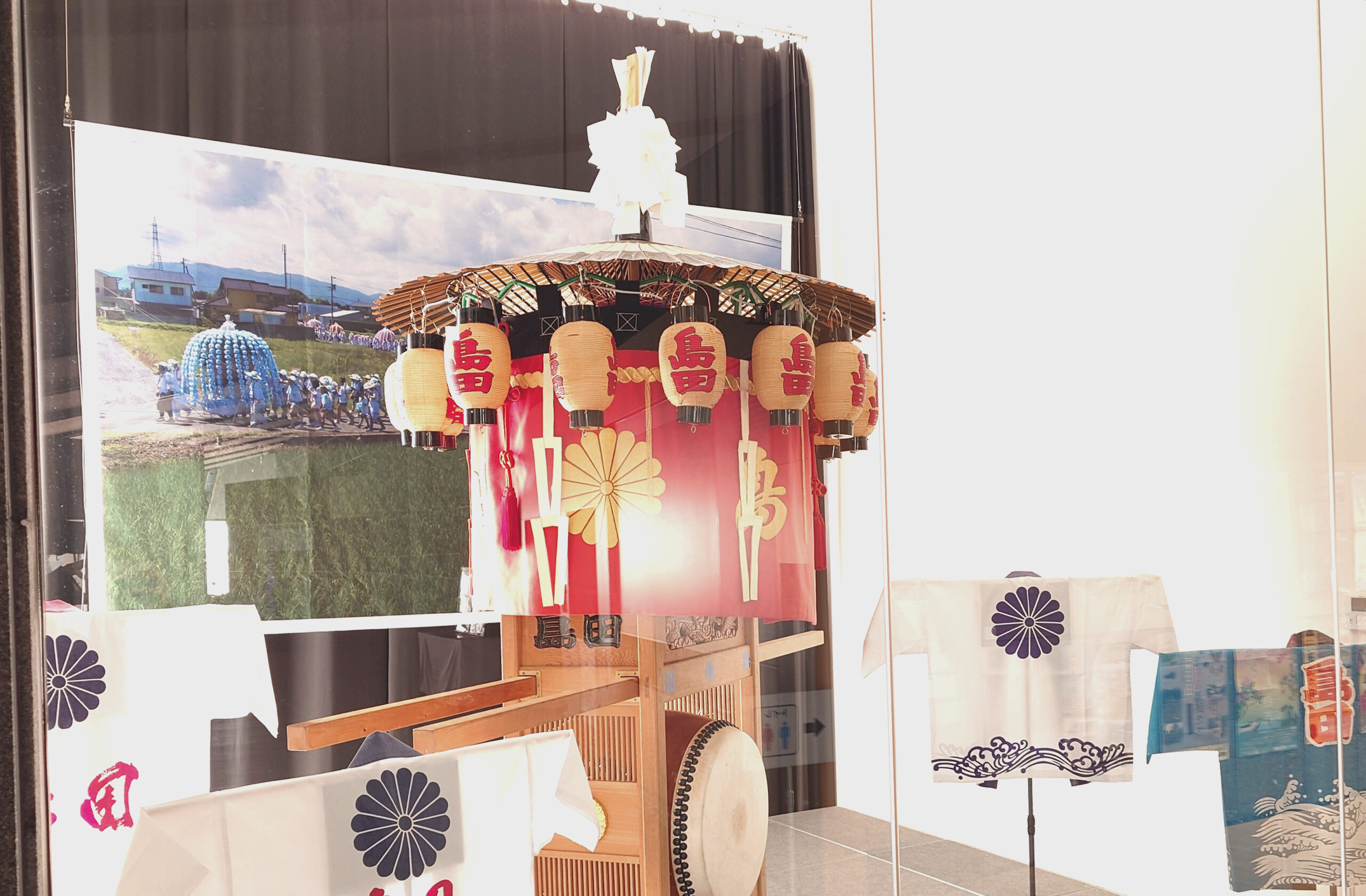 島田傘鉾の展示写真。島田の文字がかかれた法被も四枚展示されている